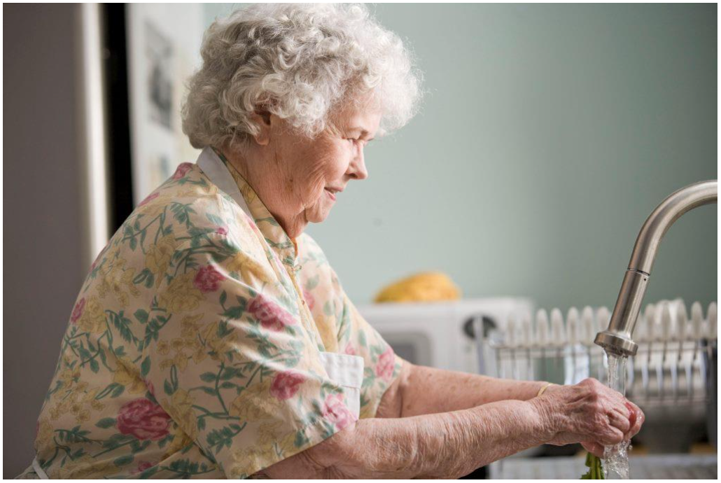 An elderly lady washing up